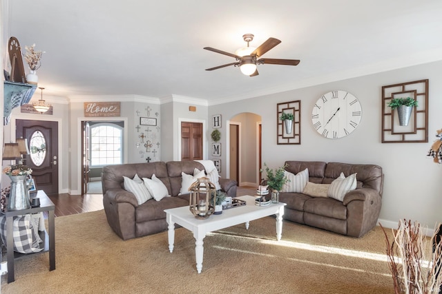 living room with ornamental molding, wood-type flooring, and ceiling fan