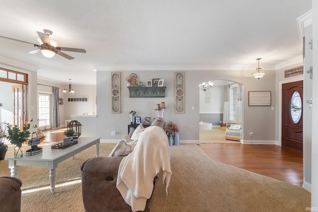 living room with ceiling fan, ornamental molding, and wood-type flooring