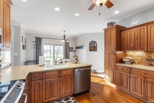 kitchen with hardwood / wood-style floors, sink, hanging light fixtures, stainless steel appliances, and crown molding