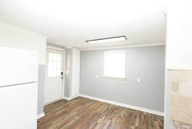 empty room with dark wood-type flooring and crown molding