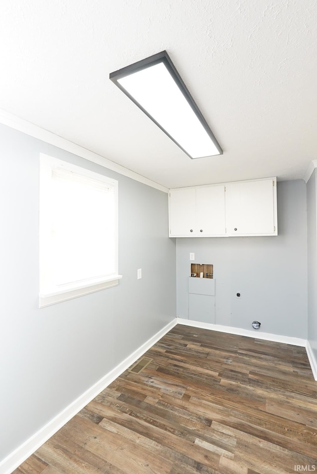 clothes washing area featuring cabinets, ornamental molding, dark hardwood / wood-style flooring, washer hookup, and hookup for an electric dryer