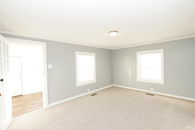 unfurnished room featuring crown molding and light carpet