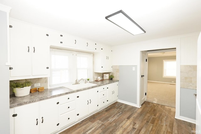 kitchen featuring white cabinetry, dark hardwood / wood-style floors, sink, and backsplash