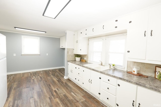 kitchen with dark hardwood / wood-style floors, sink, white cabinets, decorative backsplash, and ornamental molding