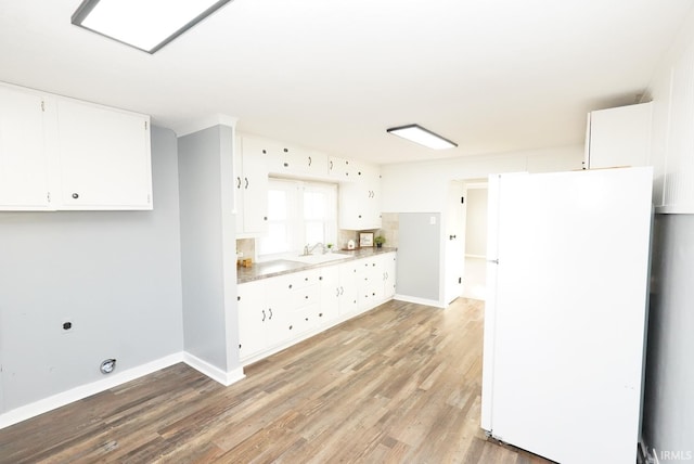 kitchen featuring white fridge, sink, white cabinets, and light hardwood / wood-style flooring