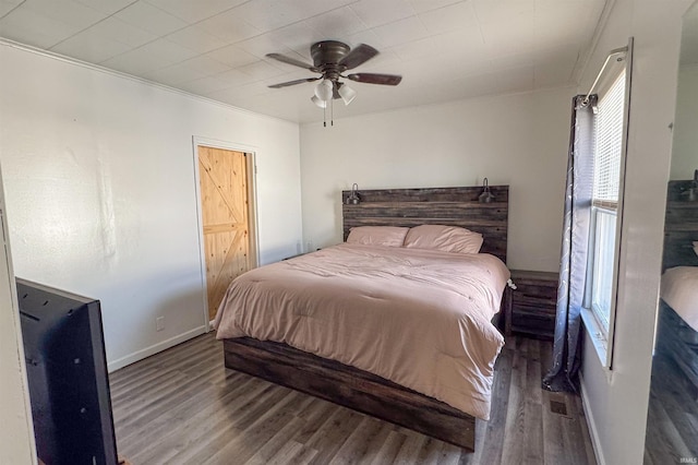 bedroom featuring ornamental molding, dark hardwood / wood-style floors, and ceiling fan