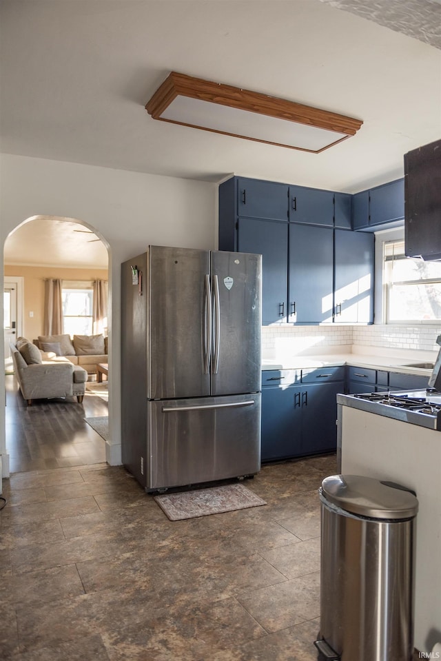 kitchen featuring a healthy amount of sunlight, blue cabinetry, and stainless steel fridge