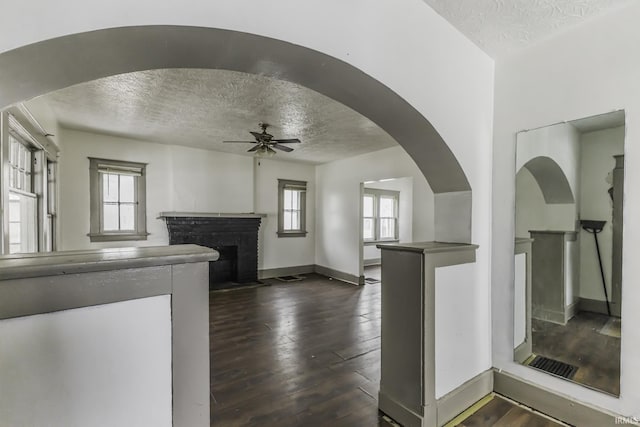 kitchen with dark wood-type flooring, a wealth of natural light, a fireplace, and a textured ceiling