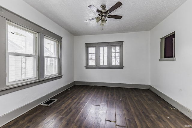 unfurnished room featuring ceiling fan, dark wood-type flooring, and a textured ceiling