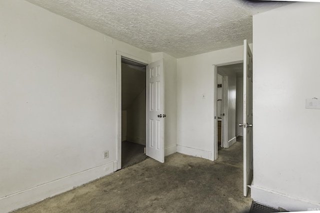 unfurnished bedroom with dark carpet and a textured ceiling