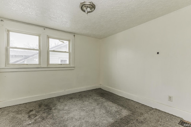 carpeted spare room with a textured ceiling