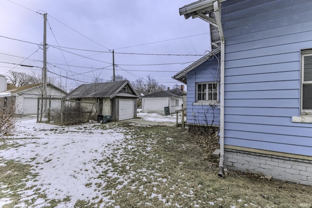 snowy yard with an outbuilding and a garage