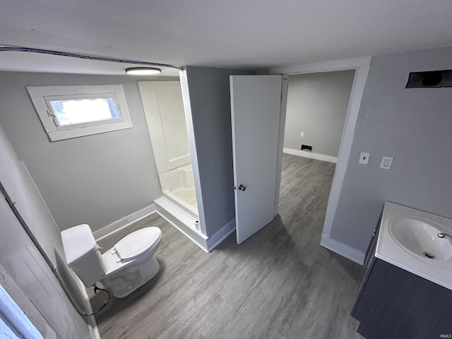 bathroom with vanity, toilet, wood-type flooring, and a shower