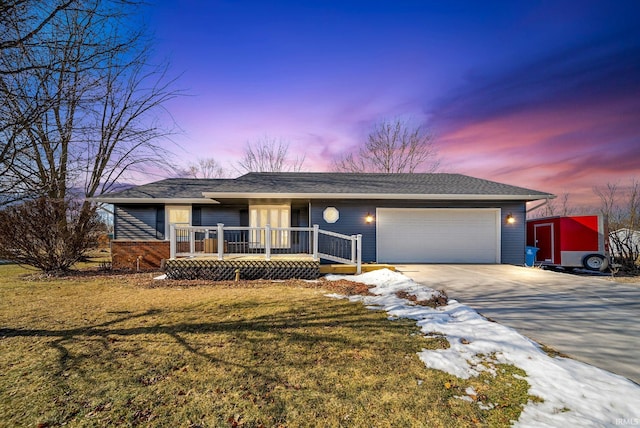 ranch-style house featuring a garage and a lawn