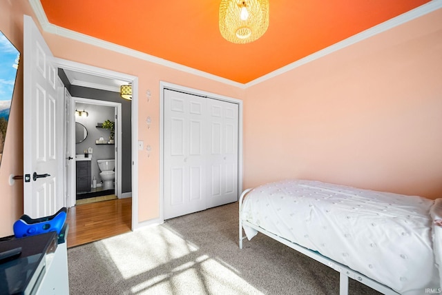 carpeted bedroom with crown molding and a closet