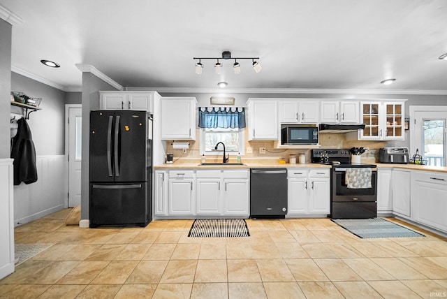 kitchen featuring sink, white cabinetry, crown molding, light tile patterned floors, and black appliances