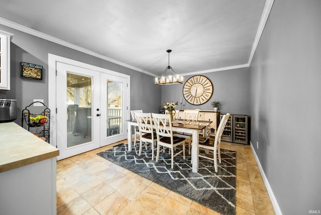 dining area featuring an inviting chandelier, ornamental molding, and french doors