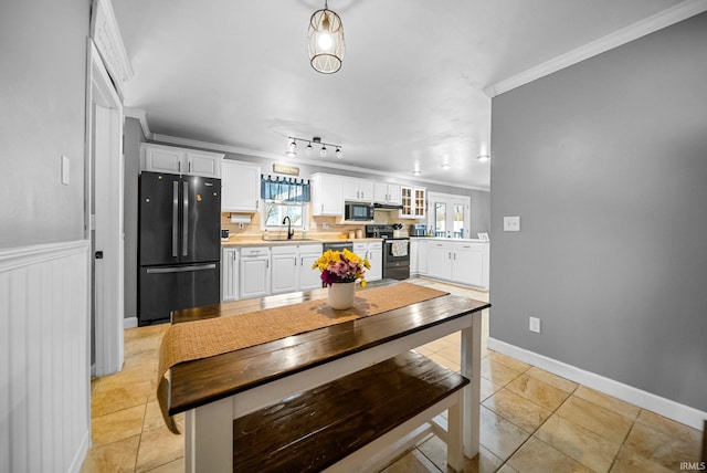 kitchen with sink, black appliances, light tile patterned floors, ornamental molding, and white cabinets