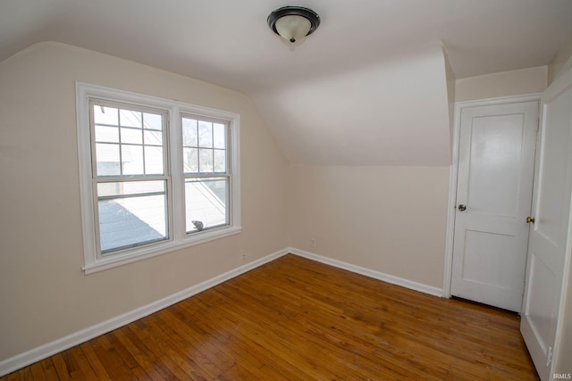 additional living space with lofted ceiling and hardwood / wood-style floors