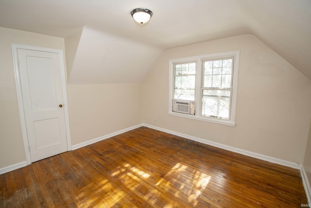 additional living space with vaulted ceiling, cooling unit, and dark hardwood / wood-style flooring