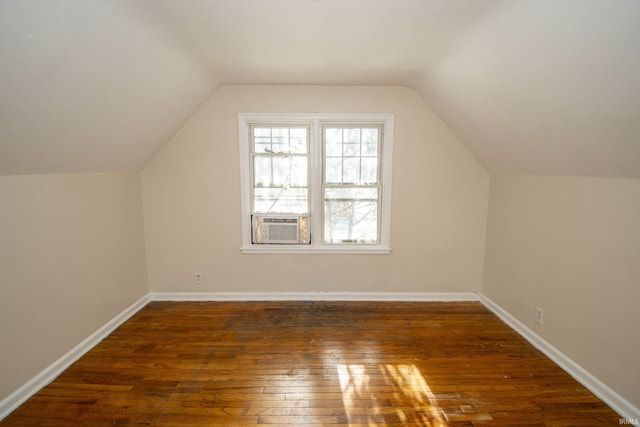 additional living space with lofted ceiling, cooling unit, and dark hardwood / wood-style floors