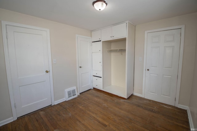 unfurnished bedroom with dark hardwood / wood-style floors and a closet