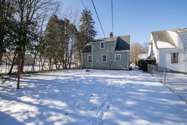 view of snow covered rear of property