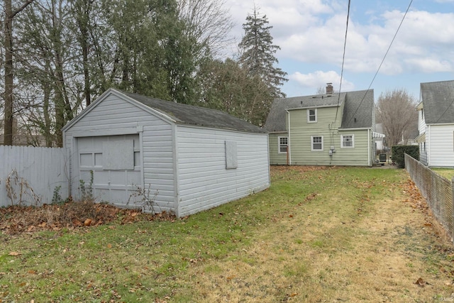 rear view of house with an outbuilding and a lawn