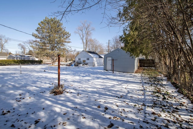 snowy yard with an outbuilding