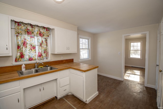 kitchen featuring white cabinetry, sink, dark wood-type flooring, and a healthy amount of sunlight