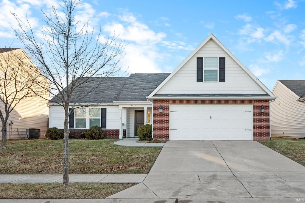 view of front facade featuring central AC, a garage, and a front yard