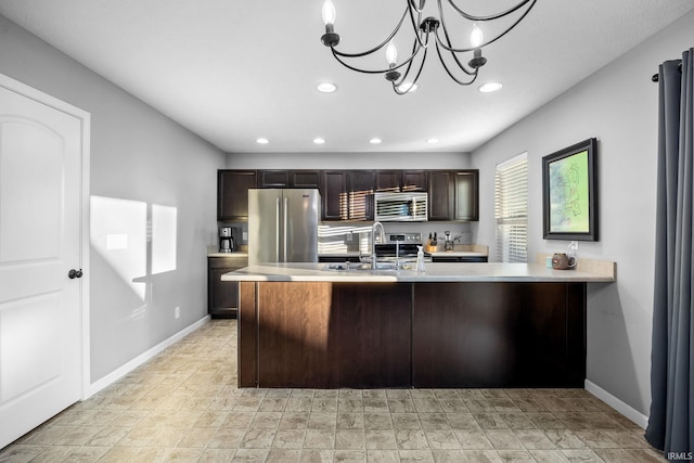 kitchen with pendant lighting, sink, appliances with stainless steel finishes, dark brown cabinets, and a chandelier