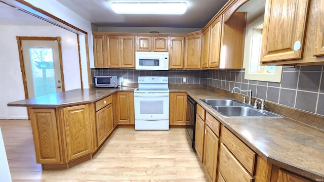 kitchen with tasteful backsplash, sink, white appliances, and light hardwood / wood-style floors