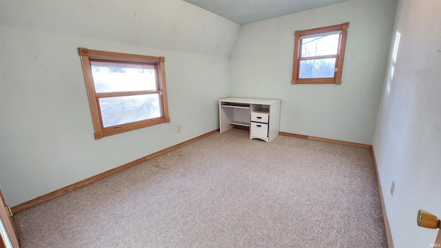 additional living space featuring lofted ceiling and light carpet