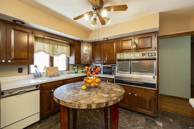 kitchen featuring ceiling fan, sink, oven, and white dishwasher