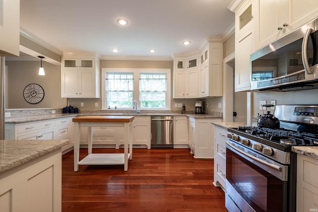 kitchen with hanging light fixtures, light stone countertops, white cabinets, and appliances with stainless steel finishes