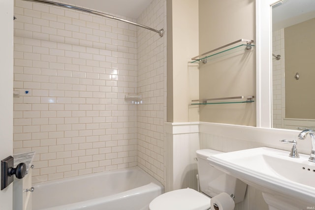 full bathroom with sink, tiled shower / bath combo, and toilet