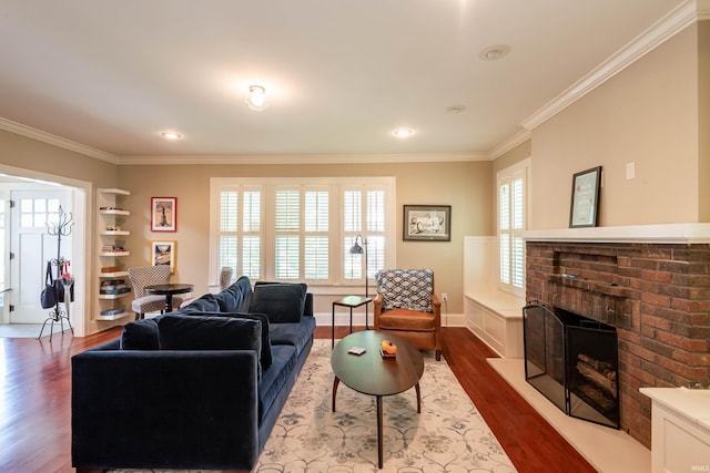 living room with crown molding, a fireplace, and hardwood / wood-style floors