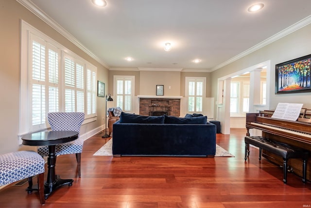 living room featuring crown molding, hardwood / wood-style flooring, and ornate columns