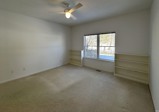 carpeted spare room with ceiling fan and a textured ceiling