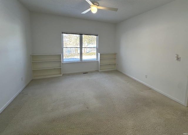 carpeted empty room with ceiling fan and a textured ceiling