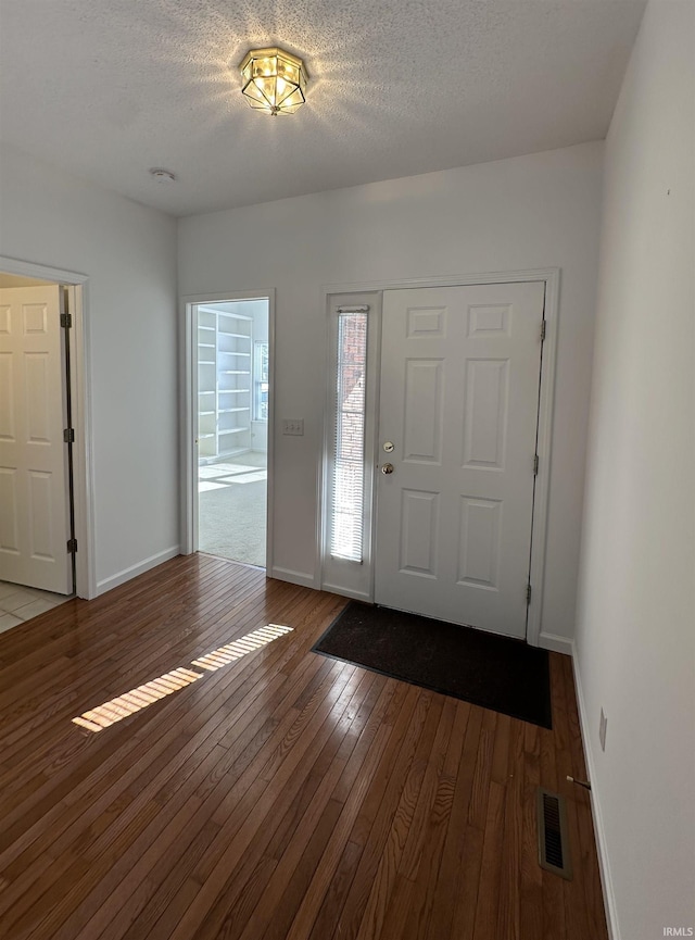 entryway featuring wood-type flooring and a textured ceiling