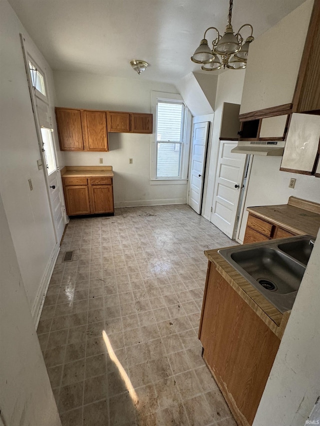 kitchen featuring an inviting chandelier, sink, and hanging light fixtures