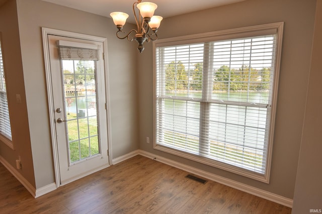 doorway featuring plenty of natural light, hardwood / wood-style floors, and a notable chandelier