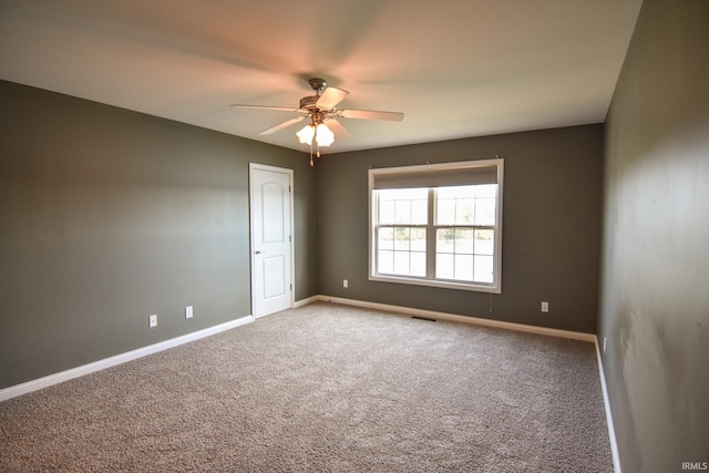 carpeted spare room featuring ceiling fan