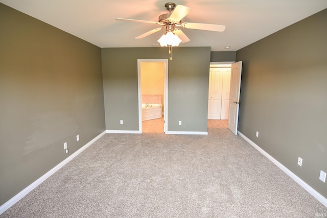 unfurnished bedroom featuring ceiling fan, light colored carpet, and connected bathroom