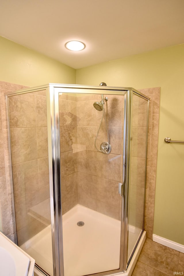 bathroom with tile patterned flooring and a shower with shower door