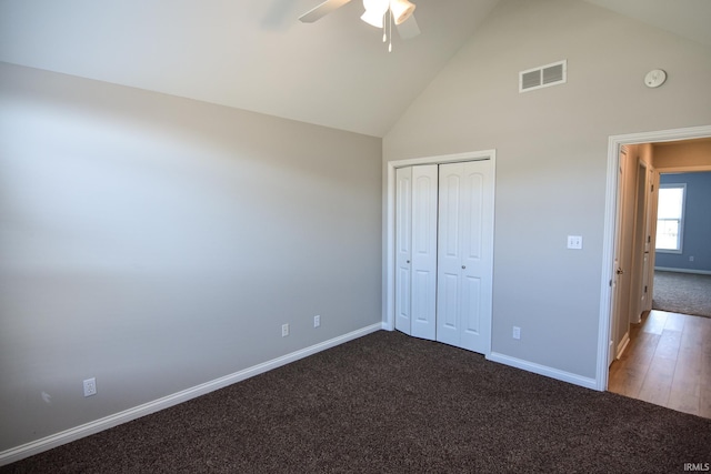 unfurnished bedroom featuring ceiling fan, carpet, high vaulted ceiling, and a closet