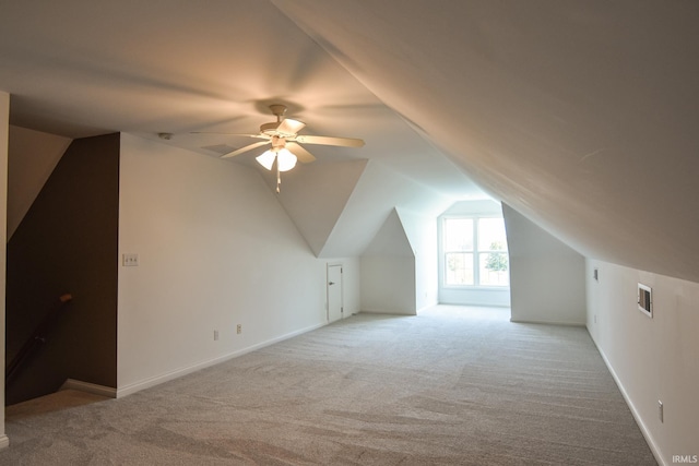 additional living space with ceiling fan, lofted ceiling, and light carpet