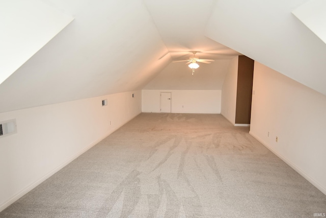 additional living space featuring vaulted ceiling, light carpet, and ceiling fan